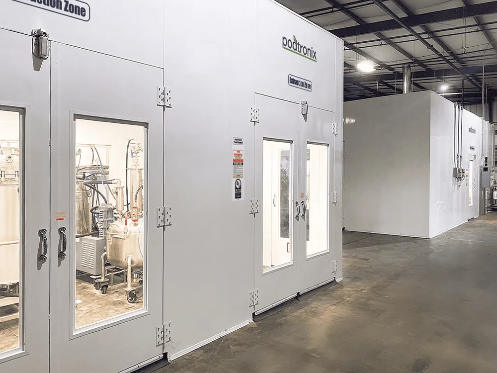 Branded Extraction Zone exterior with self-closing, self-sealing door, UL placard, and viewing window — installed inside an existing warehouse.